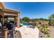 Lush backyard featuring a sparkling pool, covered patio with lounge seating, and beautiful desert landscaping with lots of cacti at 20655 N 273Rd Ave, Buckeye, AZ 85396