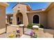 Charming front entrance with a small gated courtyard, flowering plants, and desert landscaping at 20655 N 273Rd Ave, Buckeye, AZ 85396