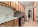 Laundry room with sink, countertops, modern appliances, and ample cabinet space at 20655 N 273Rd Ave, Buckeye, AZ 85396