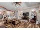Inviting living room with a fireplace, wood floors, comfortable seating, and a large television at 20655 N 273Rd Ave, Buckeye, AZ 85396