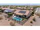 An aerial view of a backyard showcasing a sparkling pool, covered patio, desert landscaping, and solar panels at 20655 N 273Rd Ave, Buckeye, AZ 85396