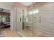 Custom tiled shower with glass enclosure and pebble floor, and neutral wall colors at 20655 N 273Rd Ave, Buckeye, AZ 85396