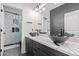 Bathroom with dual black vessel sinks and black cabinets against black and white decor at 20689 W Valley View Dr, Buckeye, AZ 85396