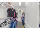 Walk-in closet features a narrow design with clothing on either side, tiled floor and a small window at 20689 W Valley View Dr, Buckeye, AZ 85396