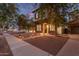 Two-story home featuring stone accents and a balcony, complemented by lush landscaping and illuminated pathway lights at 20689 W Valley View Dr, Buckeye, AZ 85396