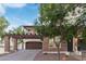 Two-story home showcasing stone accents and a balcony over the garage, complemented by front yard landscaping at 20689 W Valley View Dr, Buckeye, AZ 85396