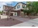 Two-story home showcasing stone accents and a balcony with front yard landscaping under a clear sky at 20689 W Valley View Dr, Buckeye, AZ 85396