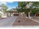 Two-story home with brick driveway, stone accents, and balcony situated over the garage under a bright sky at 20689 W Valley View Dr, Buckeye, AZ 85396