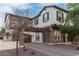 Two-story home with stone accents and a balcony situated over the garage, with a brick driveway and landscaping at 20689 W Valley View Dr, Buckeye, AZ 85396