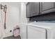 Well-equipped laundry room with modern washer, dryer, upper cabinets, and cleaning supplies at 20689 W Valley View Dr, Buckeye, AZ 85396