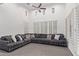 Inviting living room with high ceilings, a large sectional sofa, and plantation shutters for natural light at 20689 W Valley View Dr, Buckeye, AZ 85396