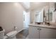 Well-lit bathroom featuring a toilet, sink and vanity with white cabinetry and stylish finishes at 21194 W Hillcrest Blvd, Buckeye, AZ 85396