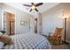 Comfortable bedroom featuring ceiling fan, rocking chair, en suite bathroom, and closet with sliding doors at 21194 W Hillcrest Blvd, Buckeye, AZ 85396