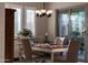 Bright dining room featuring a classic chandelier, window shutters, and sliding glass door at 21194 W Hillcrest Blvd, Buckeye, AZ 85396