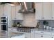 Kitchen with stainless steel KitchenAid appliances, granite countertops, and tile backsplash at 21194 W Hillcrest Blvd, Buckeye, AZ 85396