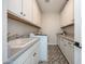 Bright laundry room with white cabinetry, countertops, washer, sink, and designer tile floor at 21194 W Hillcrest Blvd, Buckeye, AZ 85396