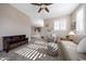 Spacious living room with plush carpeting, comfortable seating, ceiling fan, and plentiful light at 21194 W Hillcrest Blvd, Buckeye, AZ 85396