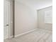 Clean, neutral bedroom featuring a door, carpet, and a window with blinds for natural light at 21228 N 58Th St, Phoenix, AZ 85054