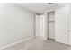 Bright bedroom featuring neutral walls, carpet, closet with white sliding doors, and a white paneled entry door at 21228 N 58Th St, Phoenix, AZ 85054