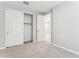 Bedroom featuring neutral walls, carpet, closet with white sliding doors, and a paneled entry door at 21228 N 58Th St, Phoenix, AZ 85054