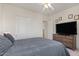 Cozy bedroom featuring a large bed, closet with sliding doors, and a television on a dresser at 2135 E Clipper Ln, Gilbert, AZ 85234