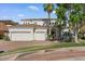 Charming front exterior with a three-car garage, well-maintained lawn, and mature palm trees at 2135 E Clipper Ln, Gilbert, AZ 85234
