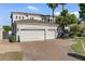 Spacious three-car garage with brick driveway, mature trees, and lush landscaping at 2135 E Clipper Ln, Gilbert, AZ 85234