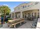 Expansive patio with a wooden dining table, hot tub, lush landscaping, and stylish outdoor seating area at 2135 E Clipper Ln, Gilbert, AZ 85234