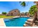 Beautiful pool and patio area with lush tropical landscaping and a two-story home in the background at 21605 S 187Th Way, Queen Creek, AZ 85142