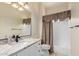 Well-lit bathroom featuring a decorative mirror, vanity and shower with neutral accents at 21605 S 187Th Way, Queen Creek, AZ 85142