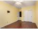 Comfortable bedroom featuring wood-look floors, a ceiling fan, and bright yellow walls at 21605 S 187Th Way, Queen Creek, AZ 85142