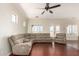 Spacious living room featuring wood floors, a ceiling fan, and a comfortable sectional couch at 21605 S 187Th Way, Queen Creek, AZ 85142