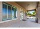 Covered patio with stone columns, double doors, and a view of the lush backyard and outdoor living space at 21605 S 187Th Way, Queen Creek, AZ 85142
