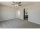 Inviting bedroom featuring neutral walls with plush carpeting, large window, and ceiling fan at 22328 W Woodlands Ave, Buckeye, AZ 85326