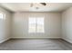 Spacious bedroom featuring neutral carpet, ceiling fan, and a window with desert views at 22328 W Woodlands Ave, Buckeye, AZ 85326