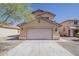 Home exterior featuring a two-car garage, neutral colors, and low maintenance landscaping at 22328 W Woodlands Ave, Buckeye, AZ 85326