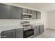 Gourmet kitchen boasts stainless steel appliances, gray cabinetry, and elegant countertops at 22328 W Woodlands Ave, Buckeye, AZ 85326