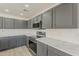 Modern kitchen boasts sleek gray cabinetry, stainless steel appliances, and elegant countertops at 22328 W Woodlands Ave, Buckeye, AZ 85326