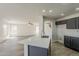 Open kitchen view with island, stainless steel sink, modern lighting and spacious living area at 22328 W Woodlands Ave, Buckeye, AZ 85326