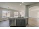 Modern kitchen island features a stainless steel dishwasher and sink with a gray cabinets and light countertops at 22328 W Woodlands Ave, Buckeye, AZ 85326
