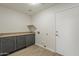 Functional laundry room with cabinets, countertop space, and exterior door access at 22328 W Woodlands Ave, Buckeye, AZ 85326