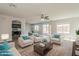 Bright, open living room with modern furnishings, ceiling fan, and adjacent dining area and kitchen at 22328 W Woodlands Ave, Buckeye, AZ 85326