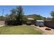 Fenced backyard with a lush lawn, storage shed, and brick firepit provides an inviting outdoor space at 25409 N 40Th Ln, Phoenix, AZ 85083