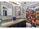Colorful bathroom with a double vanity, granite countertops, and a shower with a Lego-themed curtain at 25409 N 40Th Ln, Phoenix, AZ 85083