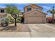 Tan two-story home featuring a two-car garage, desert landscaping, and a brick paver walkway to the front door at 25409 N 40Th Ln, Phoenix, AZ 85083