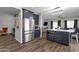 Stylish kitchen featuring navy cabinets, stainless steel appliances, a center island, and views of the living area at 25409 N 40Th Ln, Phoenix, AZ 85083