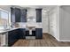 Contemporary kitchen with navy cabinets, stainless steel appliances, white subway tile backsplash, and luxury vinyl plank flooring at 25409 N 40Th Ln, Phoenix, AZ 85083