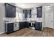 Modern kitchen features navy cabinets, white subway tile backsplash, stainless steel appliances, and luxury vinyl plank flooring at 25409 N 40Th Ln, Phoenix, AZ 85083