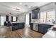 Open kitchen with navy cabinets, stainless steel appliances, a center island, and a view to the living room at 25409 N 40Th Ln, Phoenix, AZ 85083