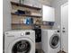 Functional laundry room with a washer, dryer, shelving, and ample storage space at 25409 N 40Th Ln, Phoenix, AZ 85083